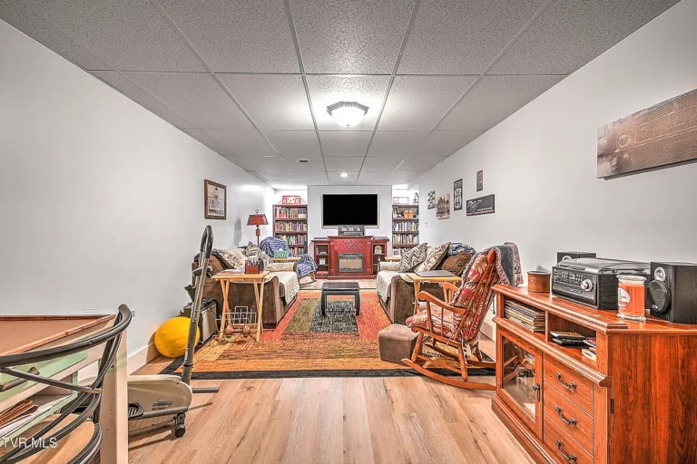 Finished basement living room with fireplace and seating in Afton