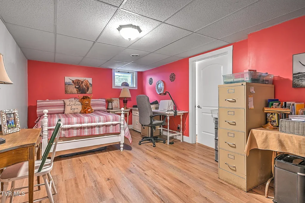 Basement bedroom with desk and wood flooring in Afton remodel