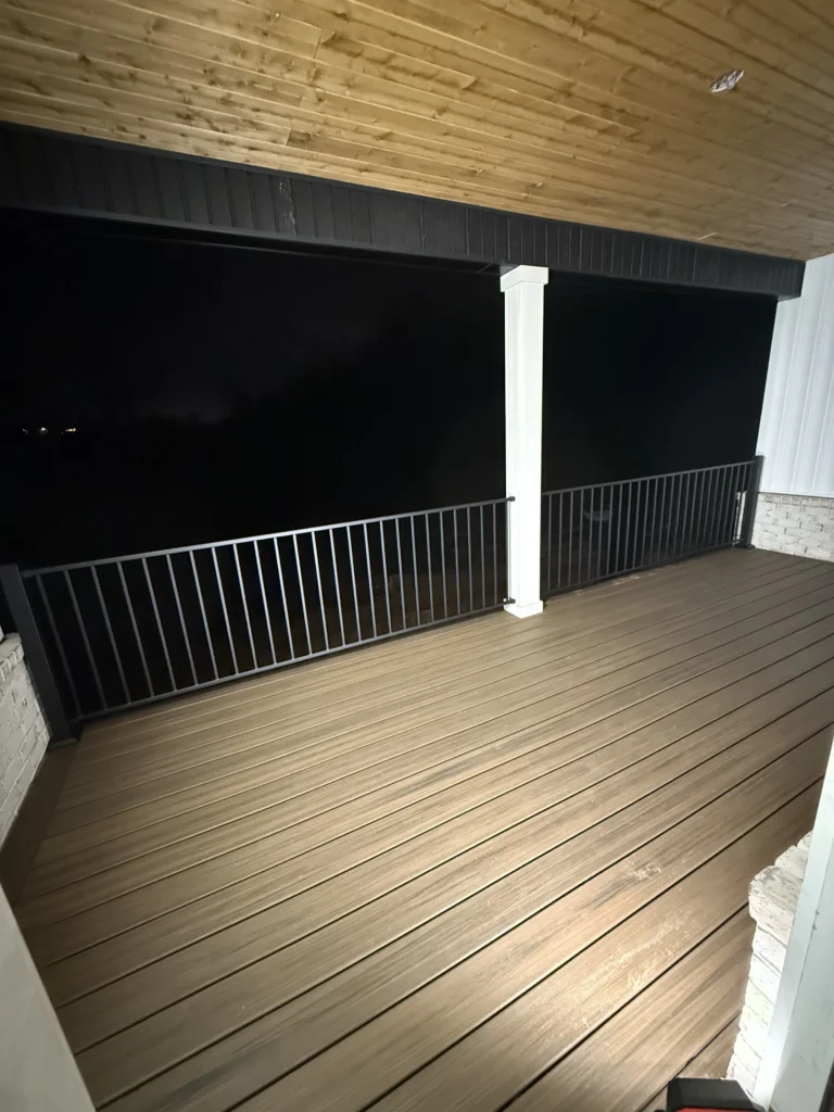 Wide view of finished Trex composite covered porch with black aluminum railing in Gray, TN