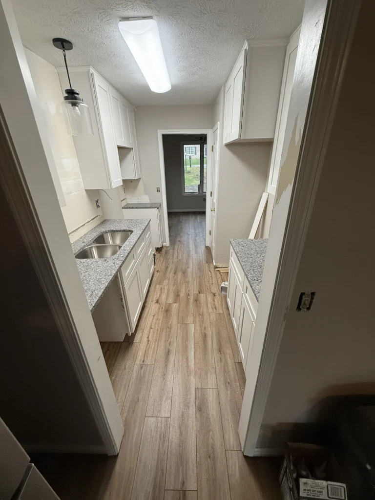 Galley kitchen with granite countertops and white cabinets in Kingsport remodel
