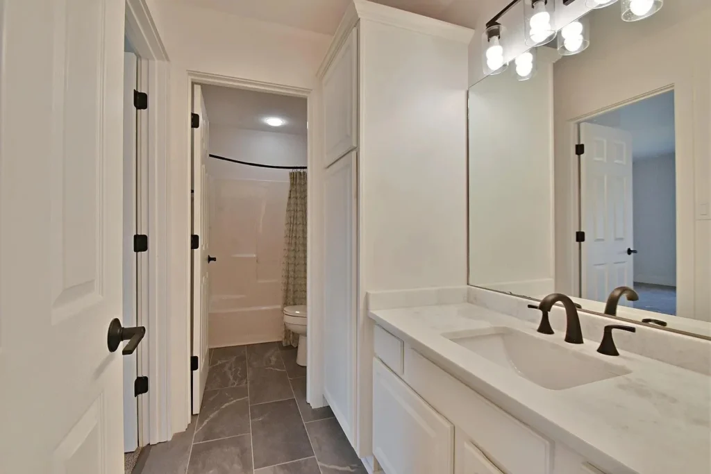 Custom single vanity with quartz countertop and black fixtures