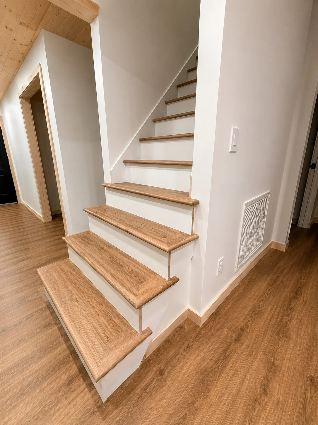 Finished wood stair treads with white risers in Piney Flats staircase remodel