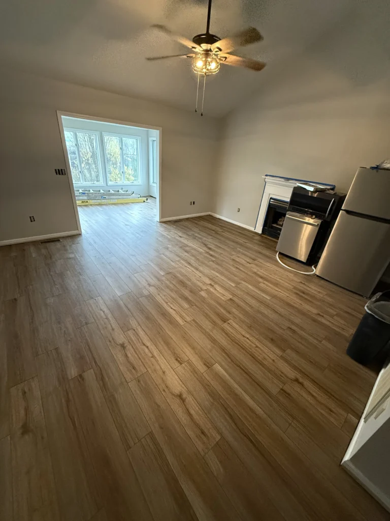 Living room with new wood-look flooring and fireplace in Kingsport home remodel